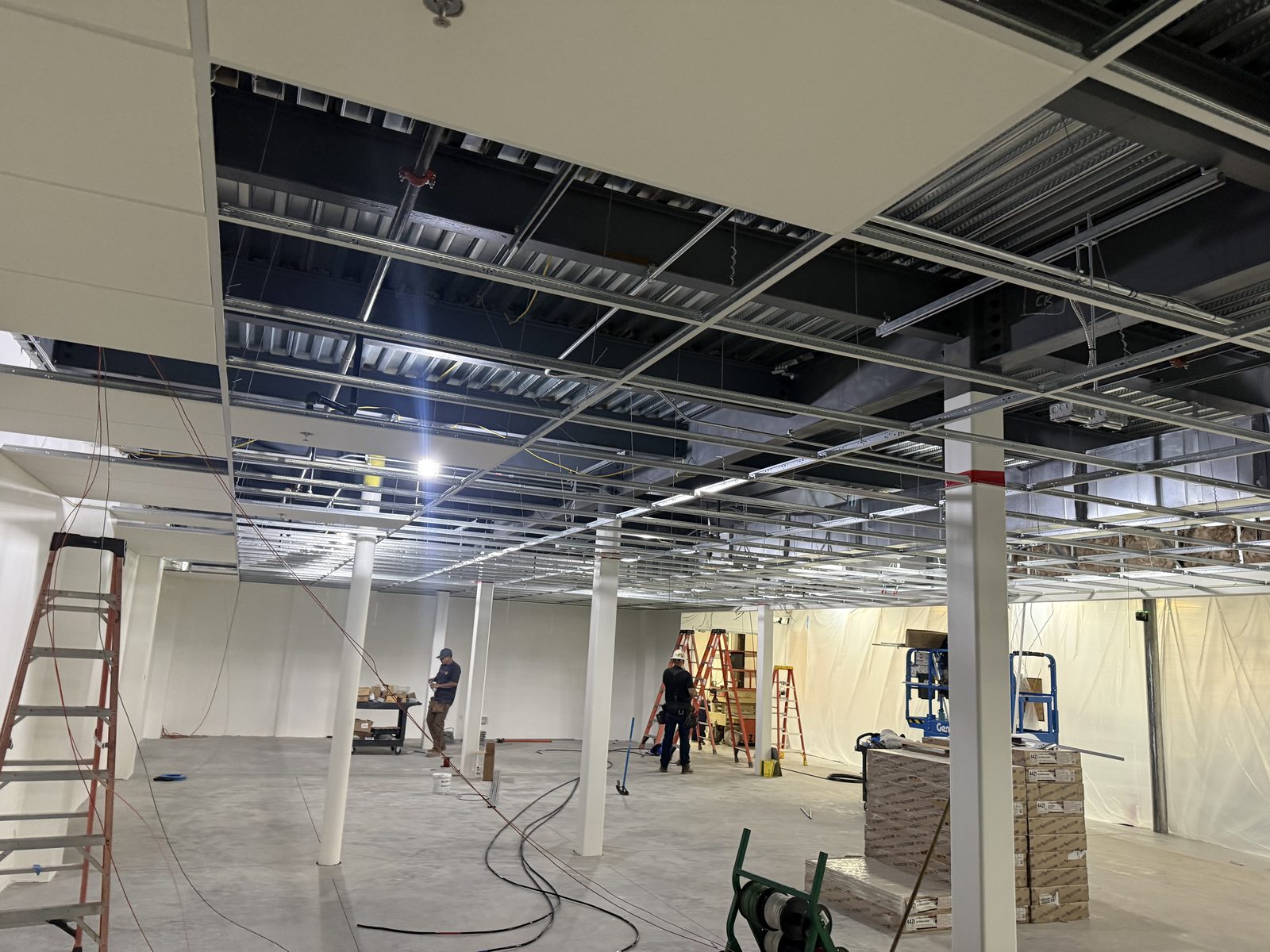 Drop-ceiling grid and acoustic tile going in with lighting and conduit above at the CBR commercial build-out by Arizona Electrical Solutions