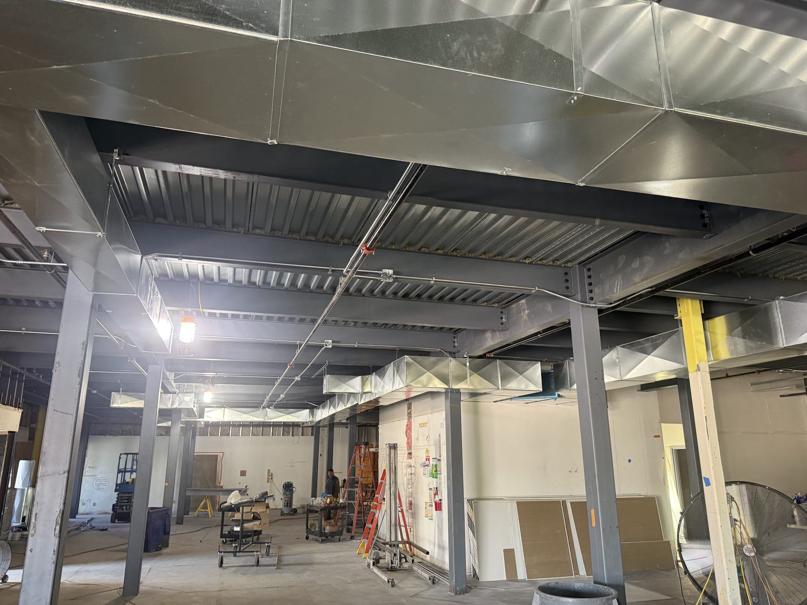 Overhead electrical conduit and HVAC ductwork coordinated under structural steel bar joists on the CBR commercial build-out by Arizona Electrical Solutions