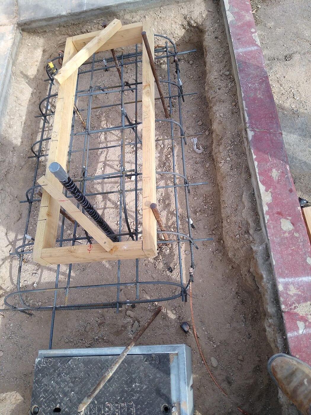 Kiosk foundation rebar with anchor-bolt template, conduit stub and grounding conductor set before the pour, Tucson, Arizona