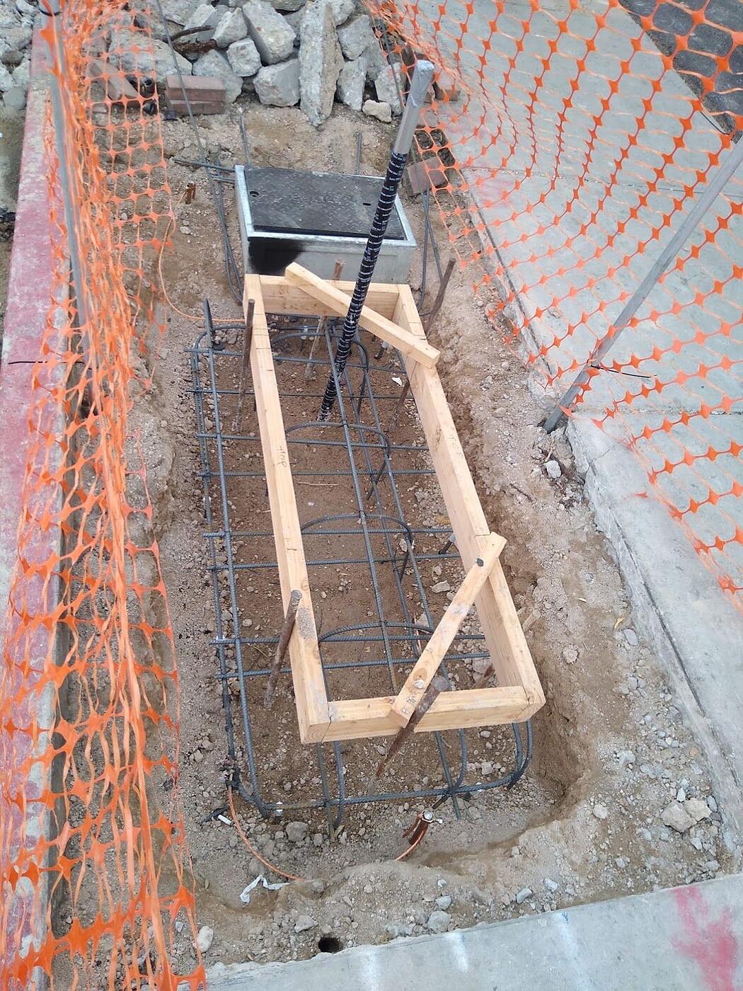 Rebar cage, formwork, conduit stub-up and pull box set in an excavation for a kiosk foundation on Fourth Avenue, Tucson