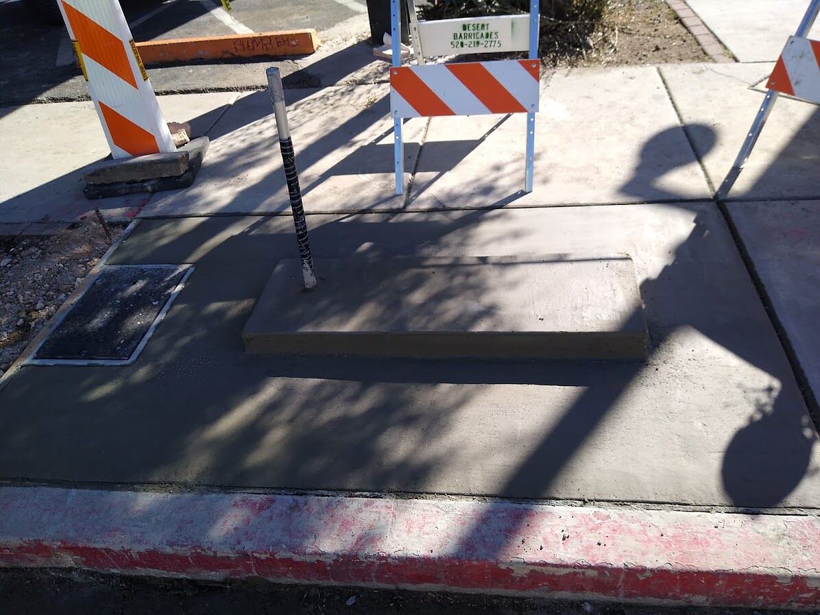 Restored sidewalk panels around a new kiosk plinth and pull box on Fourth Avenue, Tucson, Arizona