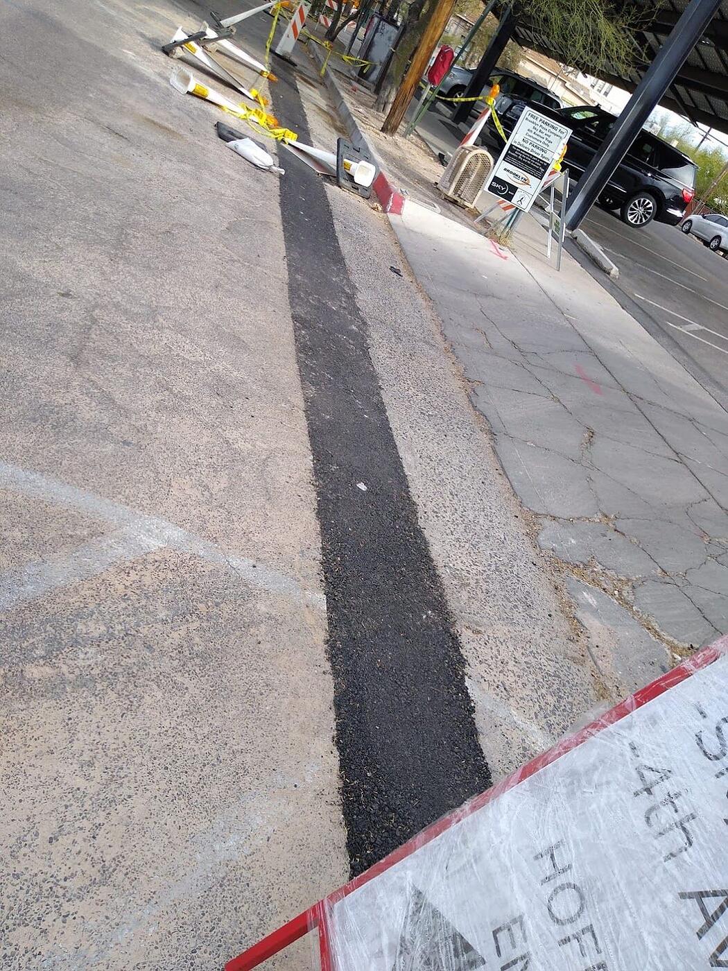 Asphalt trench patch restored in the roadway on Fourth Avenue after underground conduit installation, Tucson