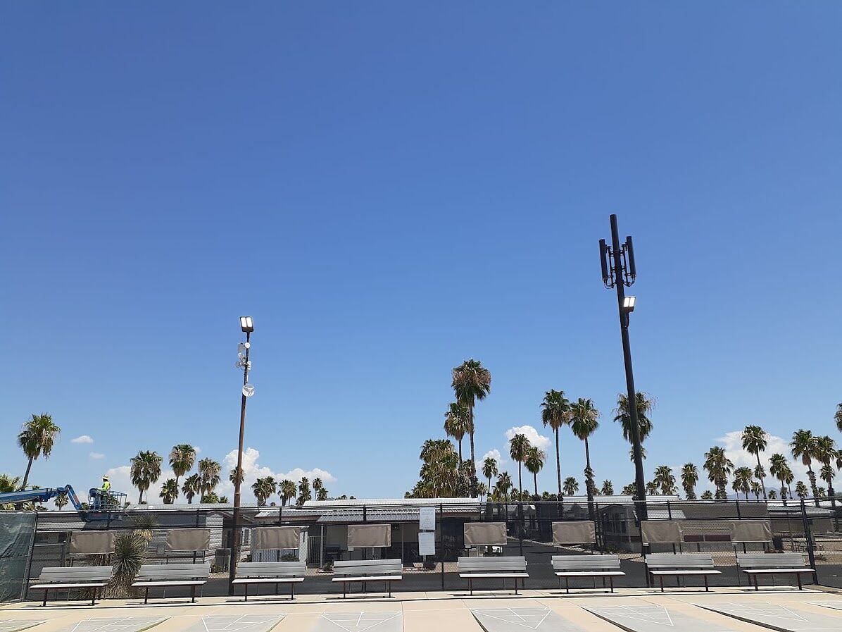 Boom lift positioned beside resort light poles during an LED fixture changeout at an RV resort in Tucson, Arizona