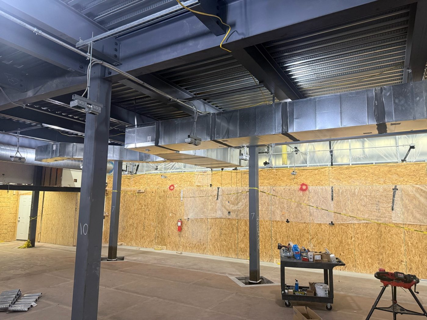 HVAC ductwork and electrical rough-in coordinated under structural steel on a commercial project in Arizona